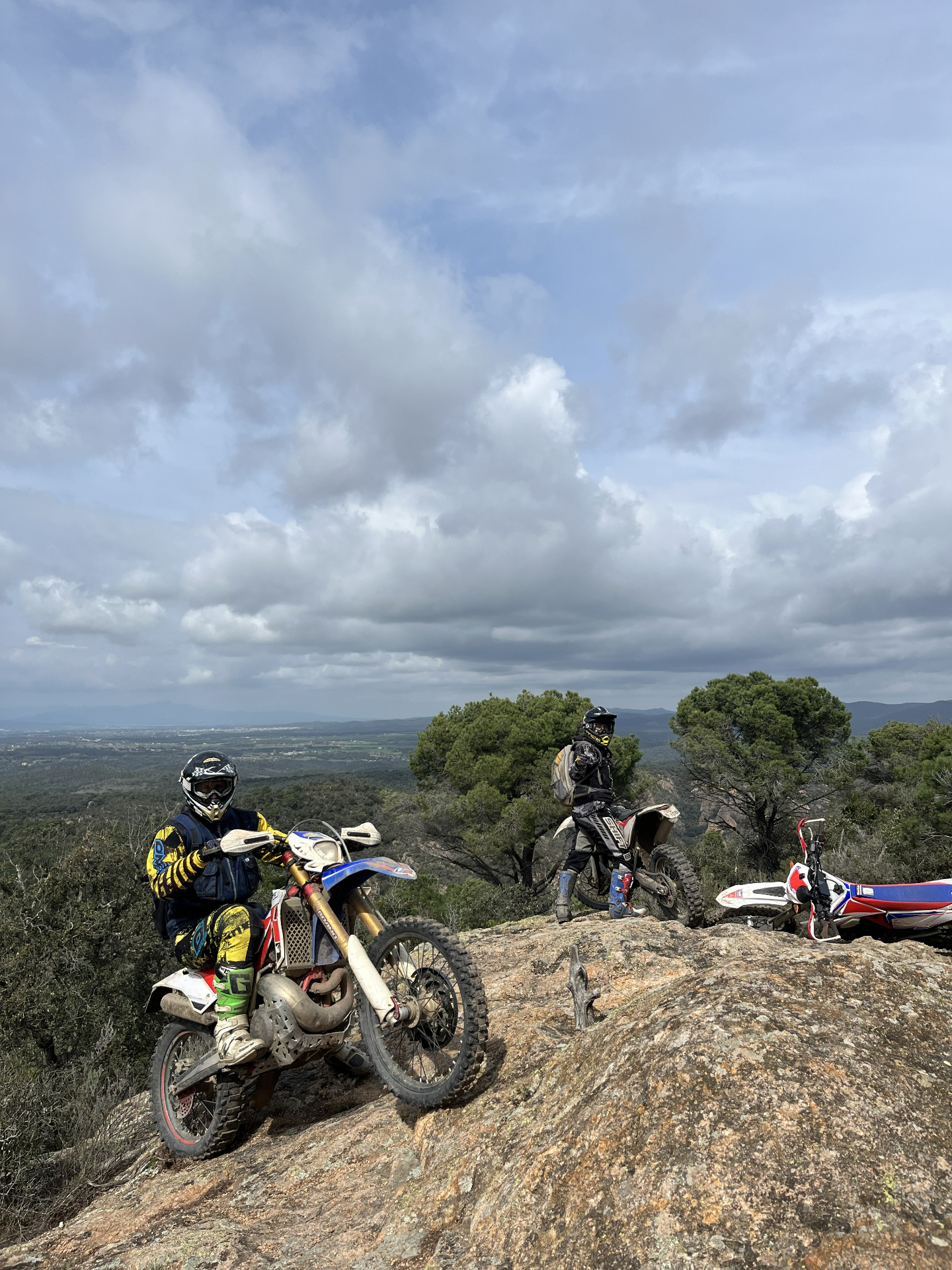 Enduro riders overlooking the Catalonia landscape from a rocky trail
