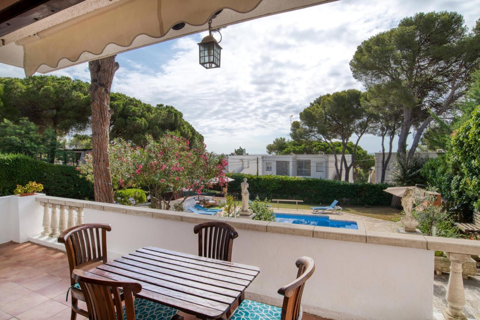 Shaded terrace with dining table overlooking the pool